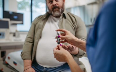 Healthcare professional prepares a syringe for a patient seated in a clinic, about to receive a vaccination.