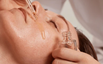 Serum infusion Close-up of a woman's face during a facial treatment as a dropper dispenses serum onto her cheek.