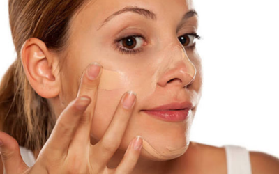 â_¢ Step 2_ Priming phase Close-up of a woman applying a clear facial mask to her cheek.